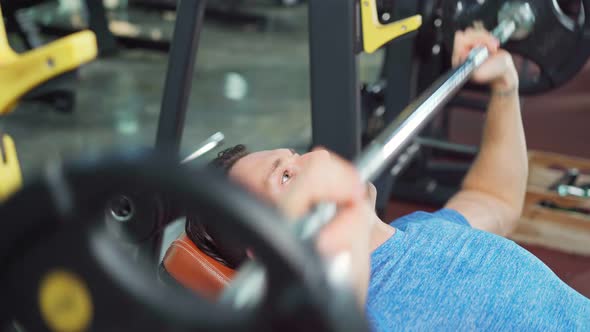 Caucasian active Fitness trainer sportsman lifting weight machine or barbell in gym club stadium.