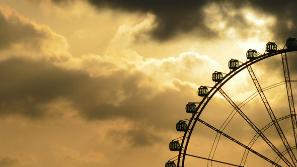 Ferris Wheel Spinning at Sundown at Cloudy Day