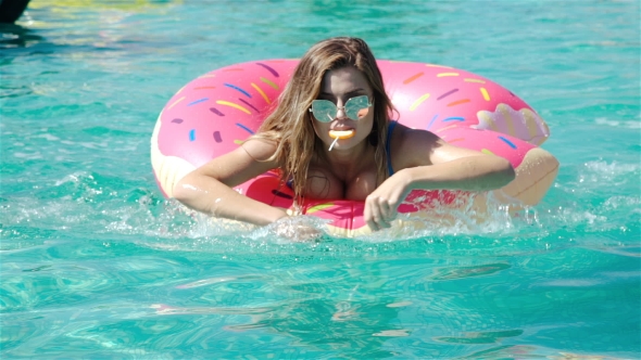 Young Hipster Millennial Girl In Sprinkled Donut Float At Pool, Festival, Party, Hotel, Beach, Event