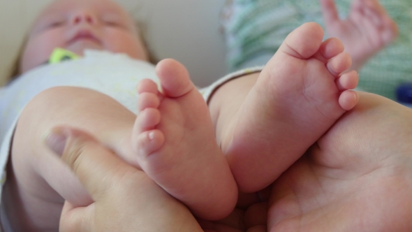 Mother Hold Feets Of Newborn Baby