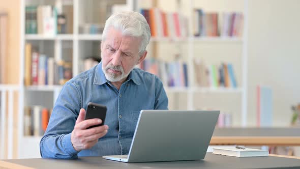 Old Man Using Smartphone and Laptop