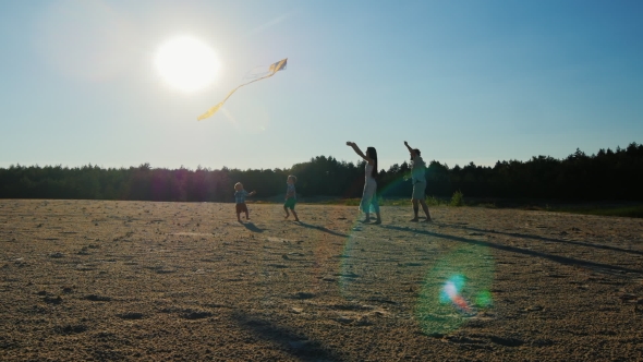 Young Family - Mom, Dad and Two Sons are Playing With a Kite