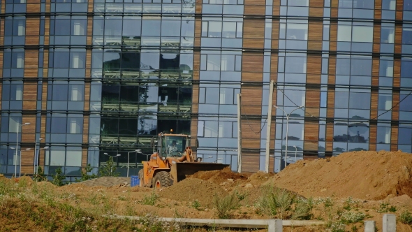 A New City Is Built: Grader Machines Working At Construction Site