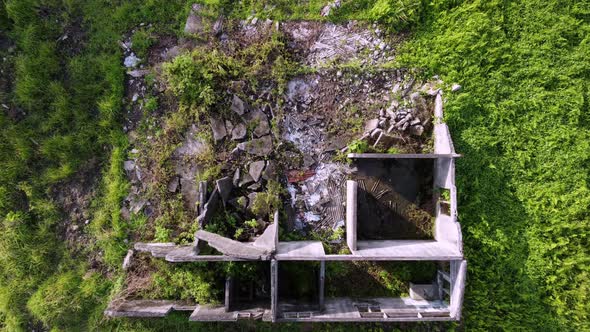 Aerial descending look down the rubbish and old abandoned concrete building