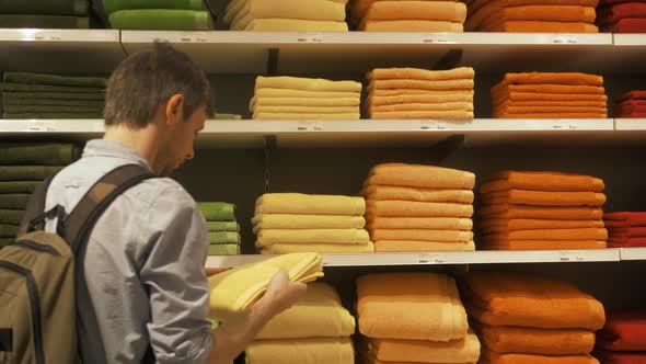 Male Man Customer Inspecting and Buying Towels in Supermarket