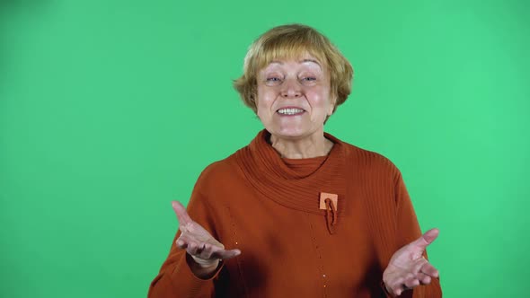 Portrait of Happy Senior Woman Is Friendly Communicates with Someone Isolated Over Green Background
