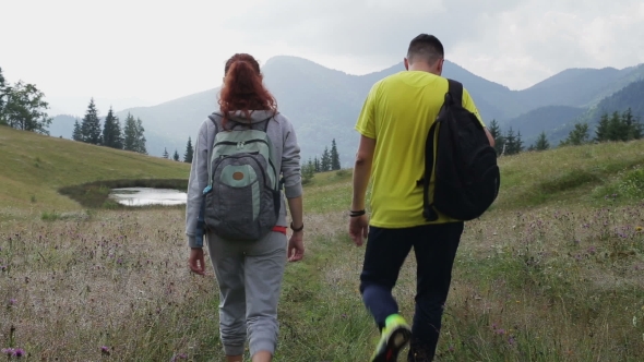 Couple Backpackers Hiking On The Path In Mountains