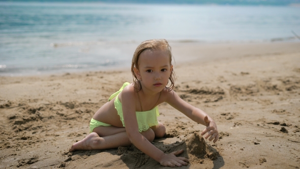 Adorable Little Girl Playing On White Sand Beach