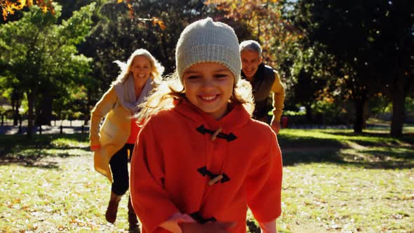 mom and dad chasing daughter outdoors