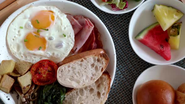 Closeup of Breakfast in Bed  Fresh Fried Eggs Ham Vegetables Fruits Salad