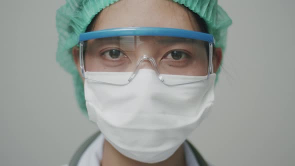 Close Up portrait Asian doctor or nurse with face mask in medical protective uniform.