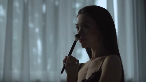 Hot Woman Playfully Uses Makeup Brush on Her Body, Making Final Adjustments