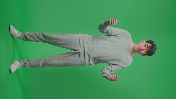 Full Body Of Asian Man Showing Gesture Hands Palm Saying Wow And Smiling In The Green Screen Studio