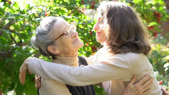 Happy Senior Mother in Eyeglasses is Hugging Her Adult Daughter the Women are Enjoying Together