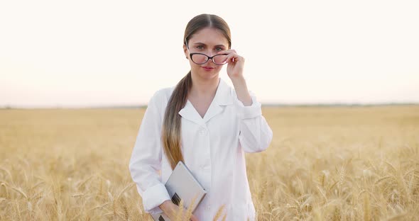 Agronomist Wearing White Coat Studying Wheat Harvest in Field