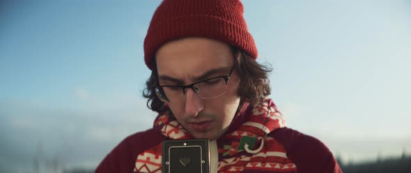 Young man using vintage camera to take pictures