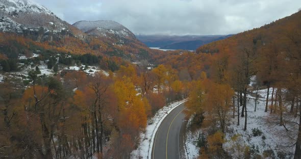 Red car tracking on a mountain road in autumn time.