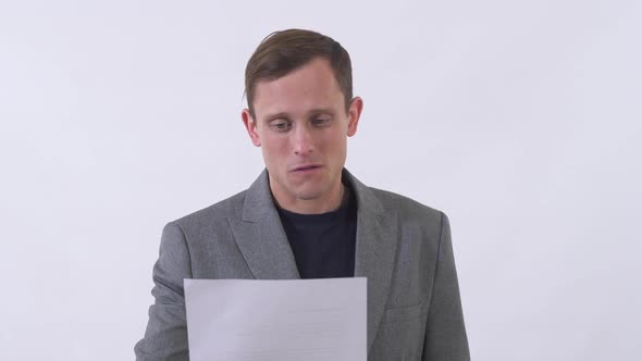 Portrait of Pleasant Man Reading Text Written on Piece of Paper Very Emotionally