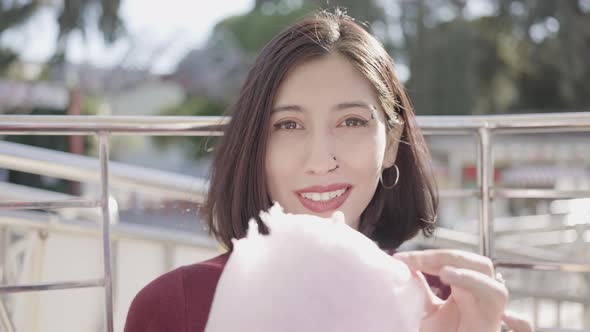 Beautiful young woman eating cotton candy