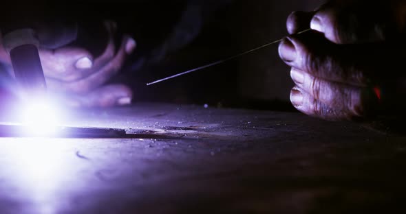 Close-up of welder using welding torch