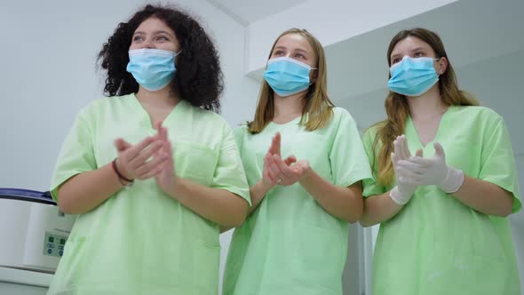 Positive Confident Women in Medical Uniform and Face Mask Clapping Rejoicing Research Success