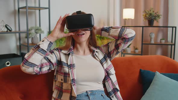 Young Woman Use Virtual Reality Headset Glasses at Home Enjoying Video Concept Moving Hands in Air