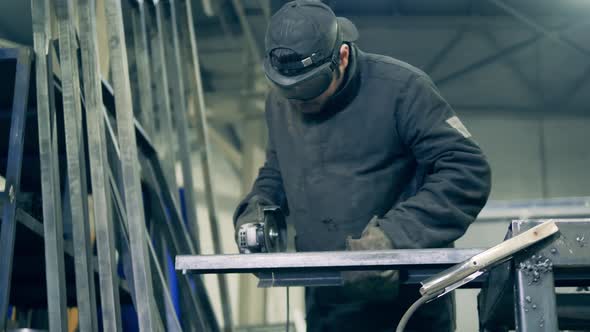 Male Technician is Cutting Steel Beams with a Rotary Saw