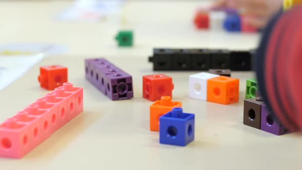 Young School Student Lining Up Colored Blocks In Class, CLOSE UP