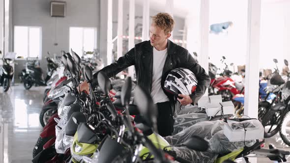 Young Man Choosing Motorbike at a Shop
