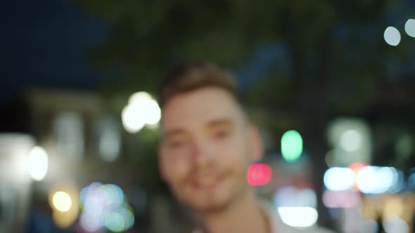 Zoom-in Portrait of Cool Tattooed Guy Outside in City Street in the Evening