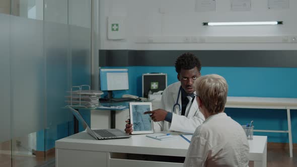 Young Physiotherapist Showing Tablet of Bones Injury