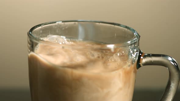 Milk poured into coffee in ultra slow motion