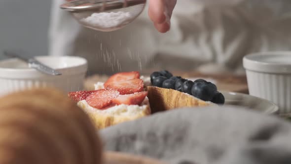 Powdered Sugar is Poured Onto Croissants