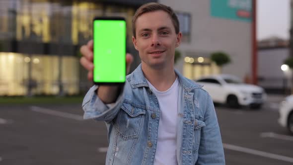 Man Showing Smartphone with Green Screen