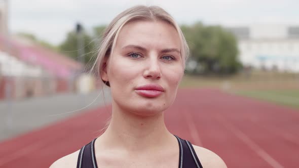 Portrait of a beautiful Caucasian female athlete looking into the camera, portrait. Athlete stands a