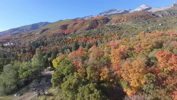 A drone flies over the rocks and slopes of  Dry Creek Trailhead in Alpine, Utah as leaves change int