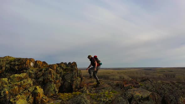 Aerial View of a Human Climbing to the Top of a Mountain