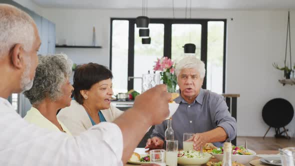 Happy senior diverse people having dinner at retirement home