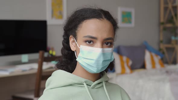 African American Teen Girl Wearing Face Mask Looking at Camera at Home