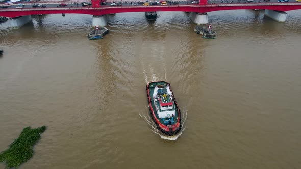 Industrial boats sailing under Ampera bridge in Palembang city, aerial tilting up view