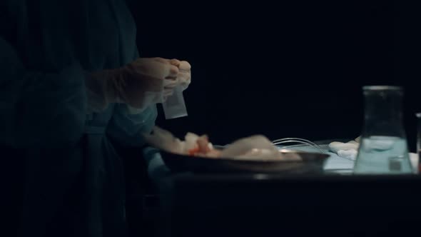Nurse Hands Preparing Tools for Wound Suturing in Dark Operating Room Closeup