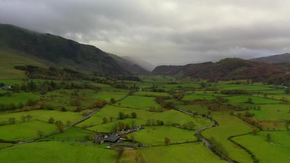 Aerial flight towards Blencathra in the Lake District in autumn with rain in the distance.