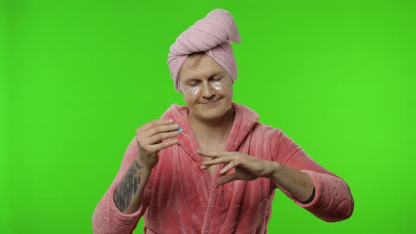 Portrait of Young Man in Bathrobe Painting His Hand Nails