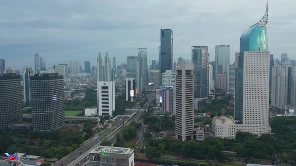 Aerial Pedestal Shot of Busy City Traffic Driving in the Modern City Center with Tall Skyscrapers in