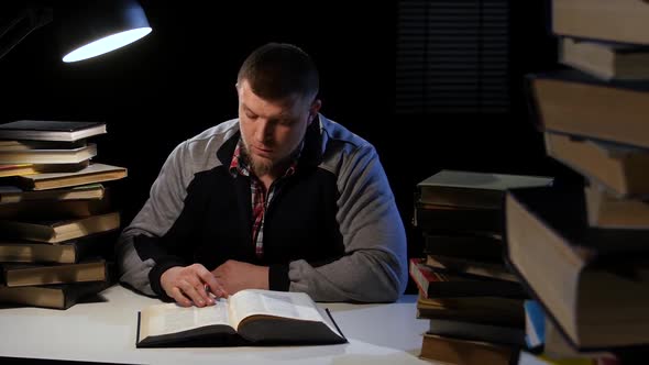 Guy in the Lamplight Records Information on Paper and Crumples It. Black Background