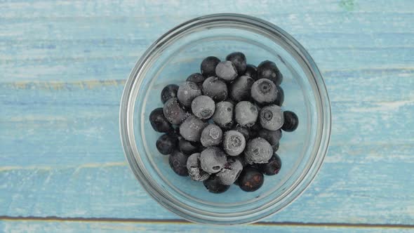 Defrosting Frozen Blueberry. Timelapse of Unfreezing, Ice Melting of Fruits, Berries on Glass Plate