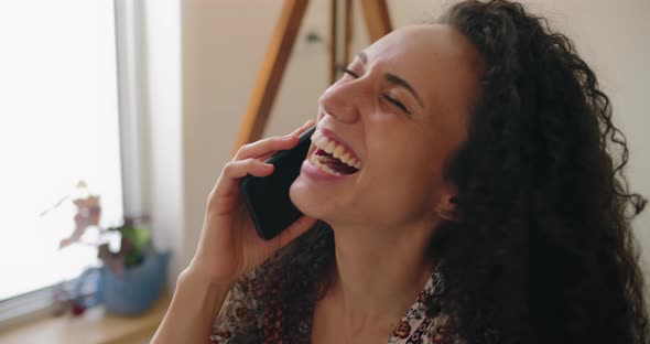 Mixed race girl laughing, talking on the phone