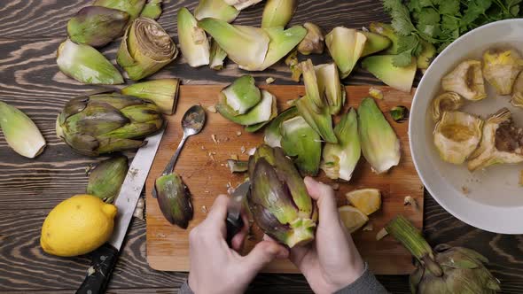 Woman Cleaning Artichokes with Knife