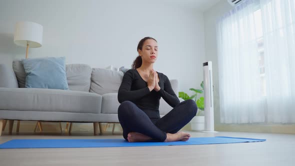 Latino young beautiful active woman doing Yoga Pilates workout  in living room in house.