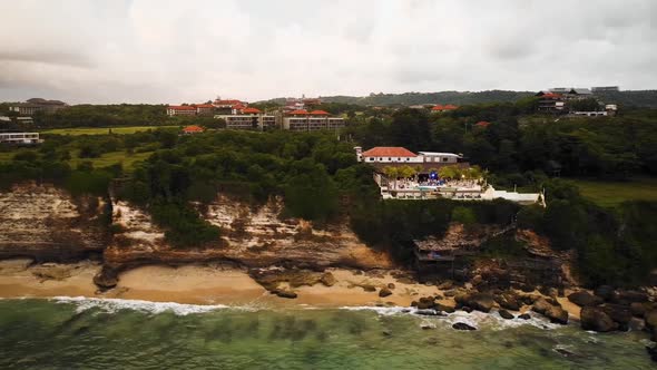 Beautiful Bingin beach with exotic cliffs houses and hotel located in Bali, Indonesia. This drone fo